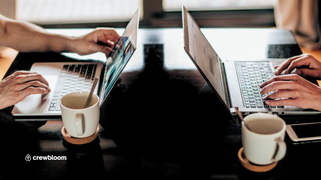 Two laptops set up for remote work, representing global collaboration and offshore teams