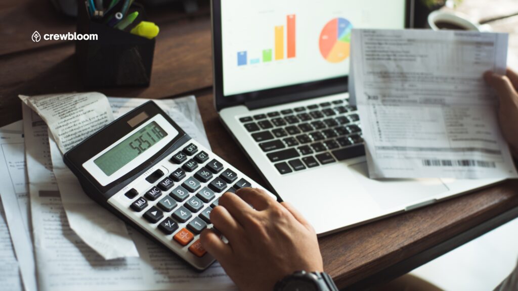 Calculator, laptop, and financial graphs representing business cost analysis and budgeting.
